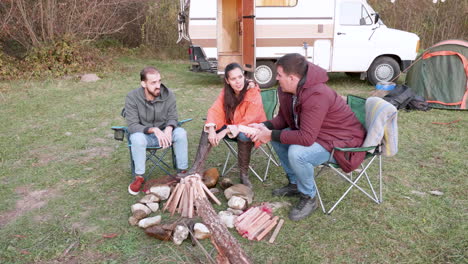 caucasian friend around camping fire in the mountains