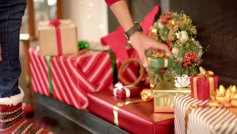 Biracial-man-putting-christmas-present-under-christmas-tree,-slow-motion