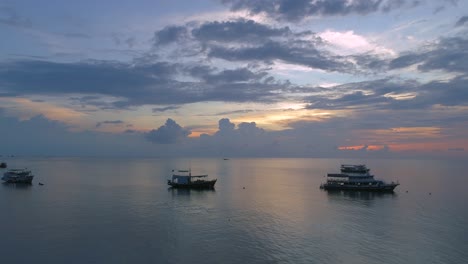 Puesta-De-Sol-Aérea-Sobre-Un-Mar-Sereno-Con-Barcos