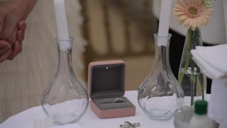 close up of wedding rings and decor on elegant ceremonial table