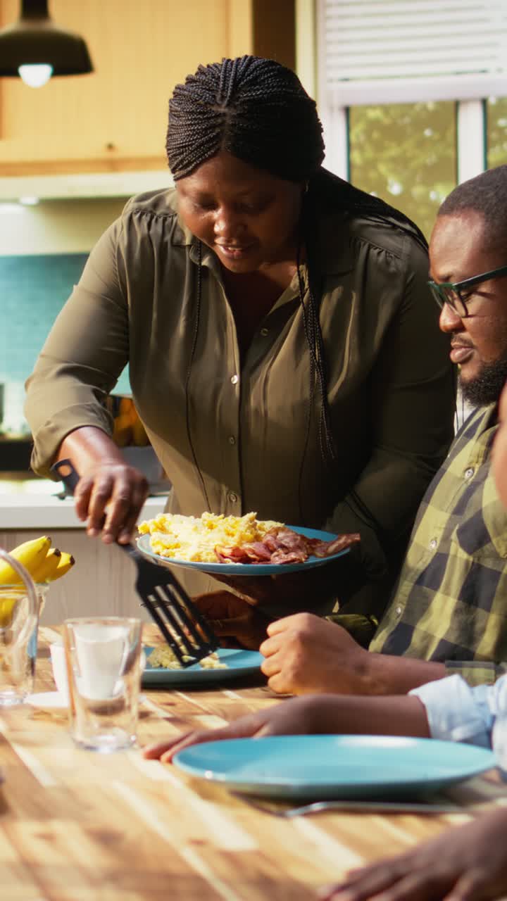 Vertical Video Happy black family enjoying breakfast together in kitchen with delicious food