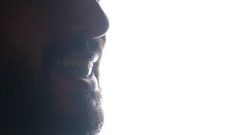 extreme close-up of male grinding teeth trying the mouthguard against bright light