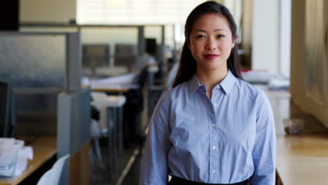 young asian businesswoman walking into focus in office