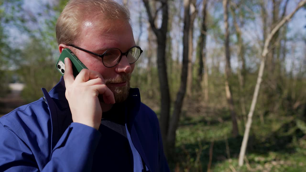 Man Receives a Phone Call, Walking in Forest, Mediun Shot from Front