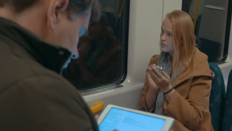 mujer escribiendo en su teléfono inteligente mientras viaja en el metro