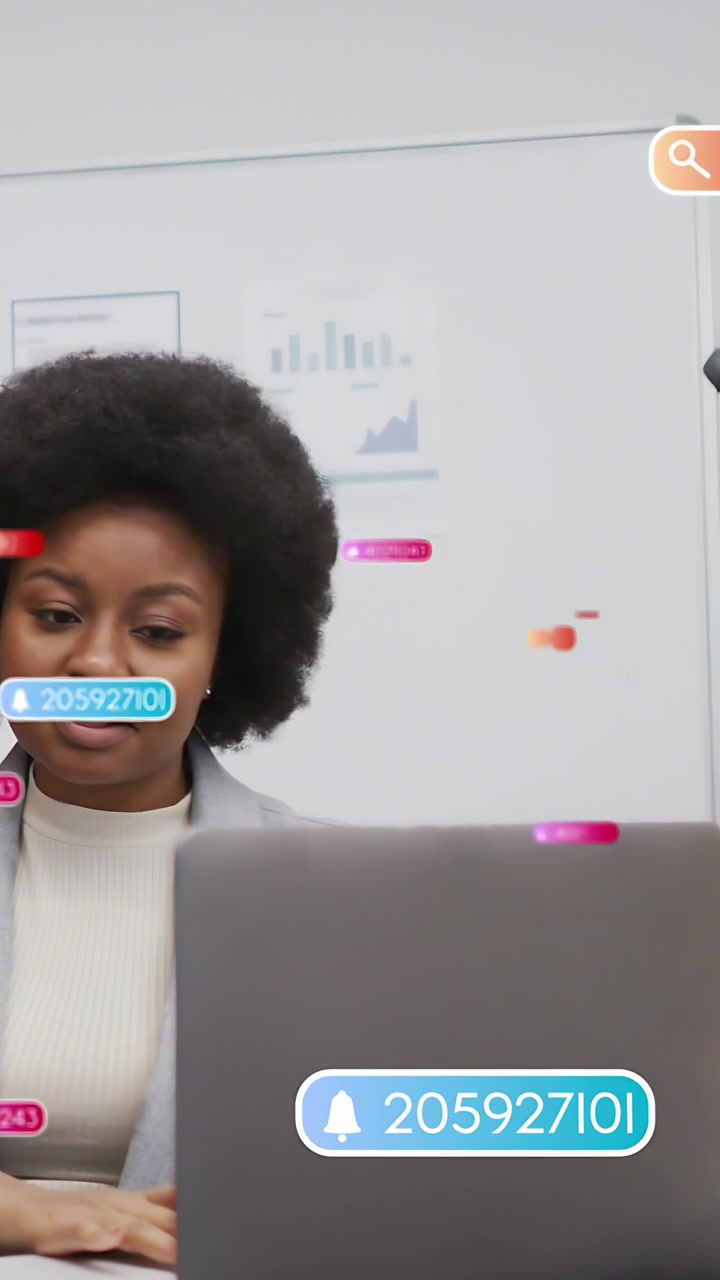 Vertical video: Woman glancing left, office badges popping over laptop and charts, reading alerts