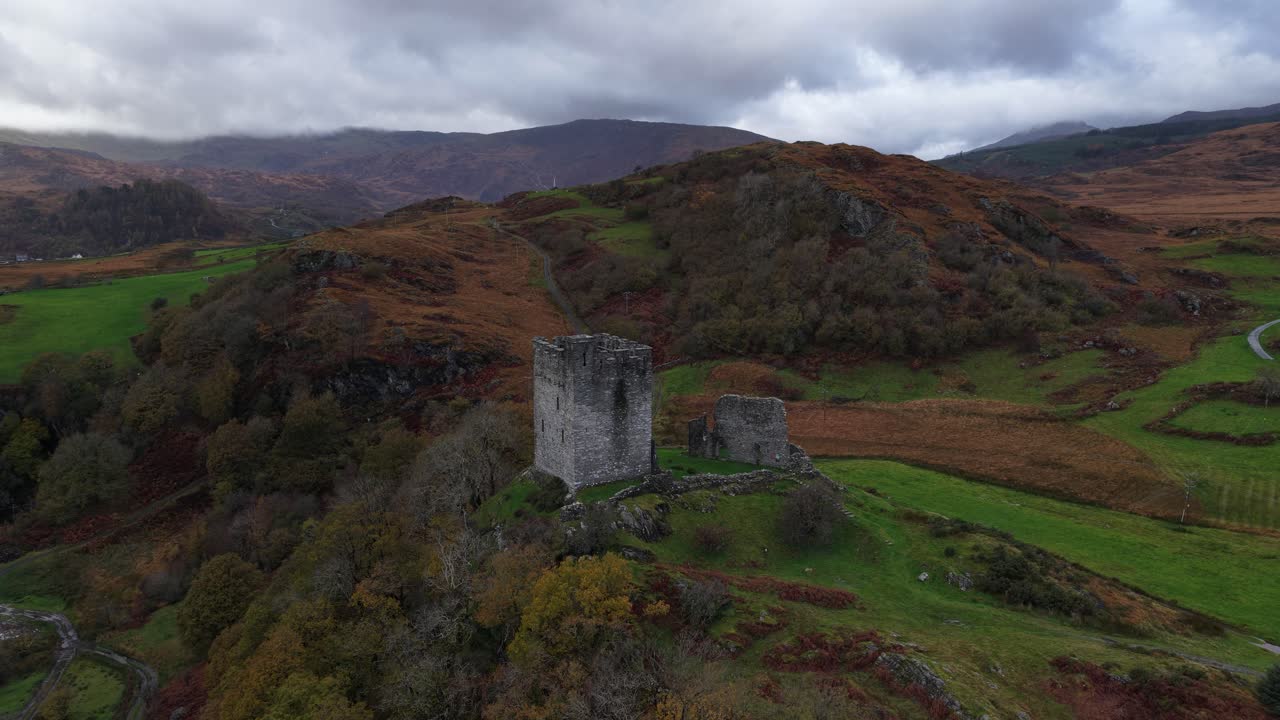 Aerial drone video of Dolwyddelan Castle in Snowdonia National Park, showing the medieval hilltop ruins and the dramatic Welsh highland landscape surrounding this historic stronghold