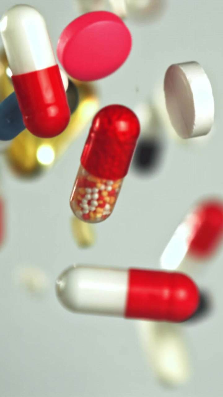 Colorful Pills and Capsules Falling in Slow Motion