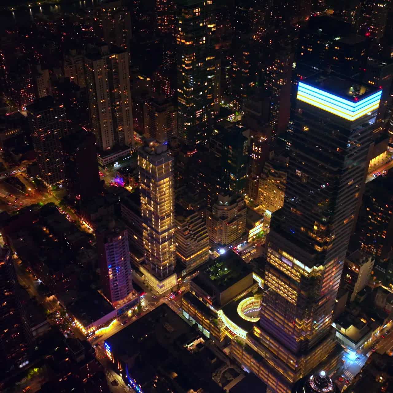 Rising high above the stunning skyscrapers of New York. Thousands of cars moving by the never sleeping city. Metropolis at night