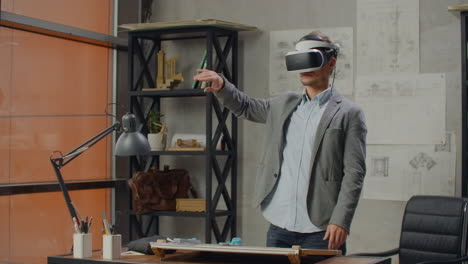 male architect in office in virtual reality helmet uses gestures to manage a project without leaving the office. construction control. design project of the building and interior