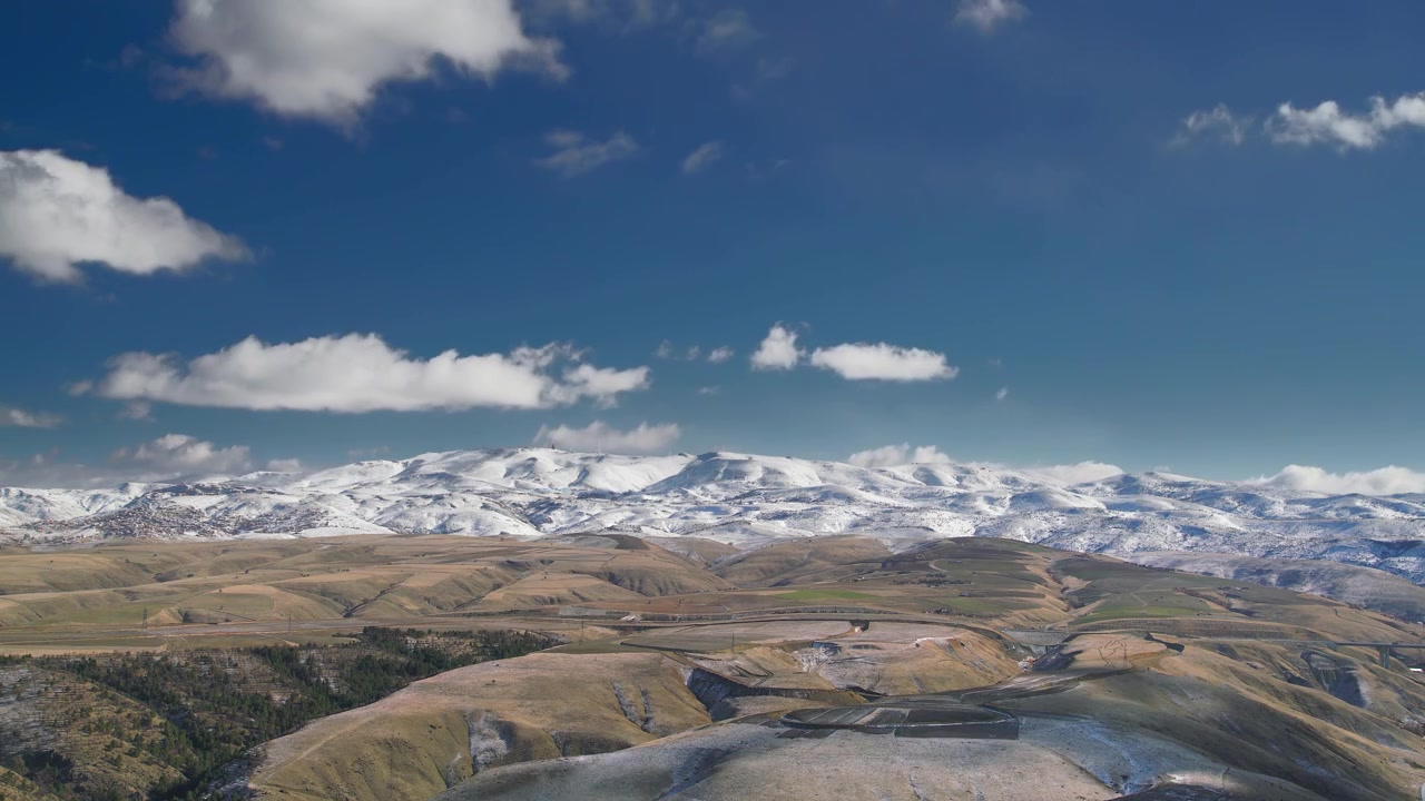Time-lapse af skyer der bevæger sig over sneklædt bjergkæde