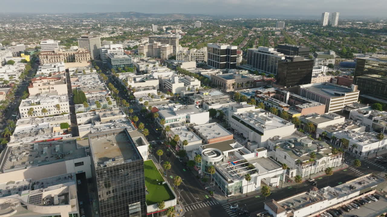 Drone sopra le trafficate strade e attività commerciali di Beverly Hills durante il giorno.