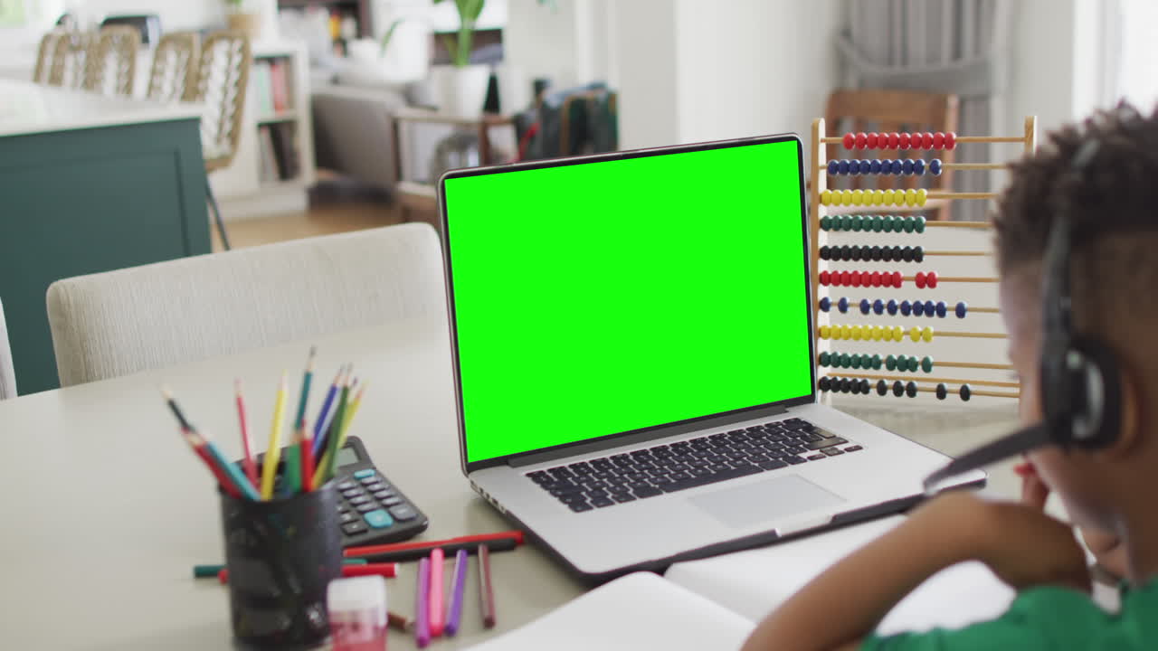 composición de un niño afroamericano en una computadora portátil aprendizaje en línea con pantalla verde