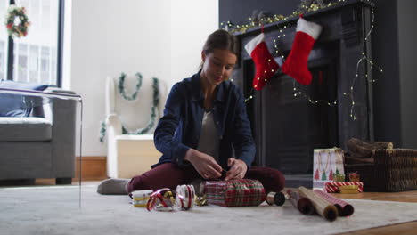 woman wrapping christmas presents at home