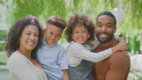 portrait de famille souriante à la maison à l'extérieur dans le jardin ensemble