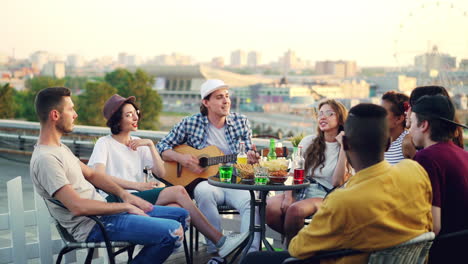 friends enjoying a rooftop party with music and drinks