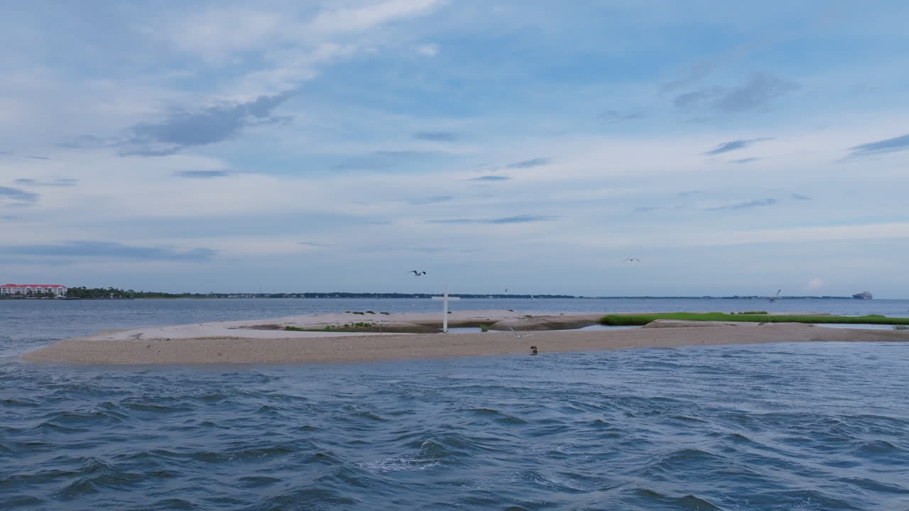 해변에 있는  십자가가 섬에 있는 새들을 빨리 어내는 공중 영상