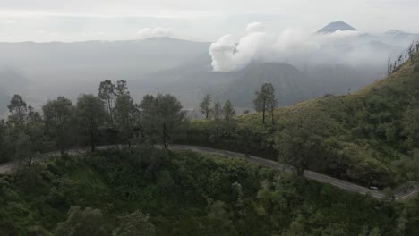 pistas aéreas de moto en el camino de alta montaña frente al volcán en java