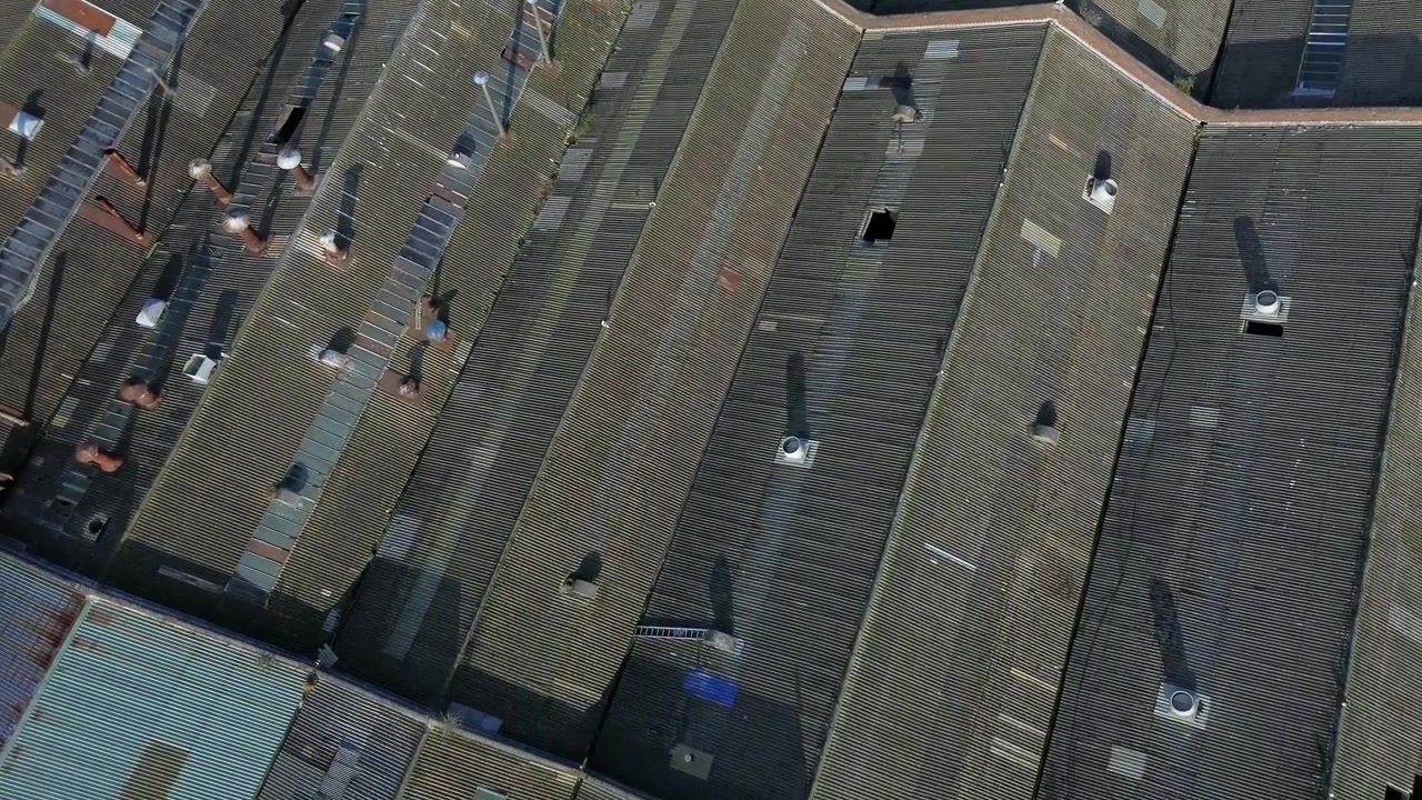 Hazardous asbestos industrial roofing aerial Birdseye view over British warehouse construction site