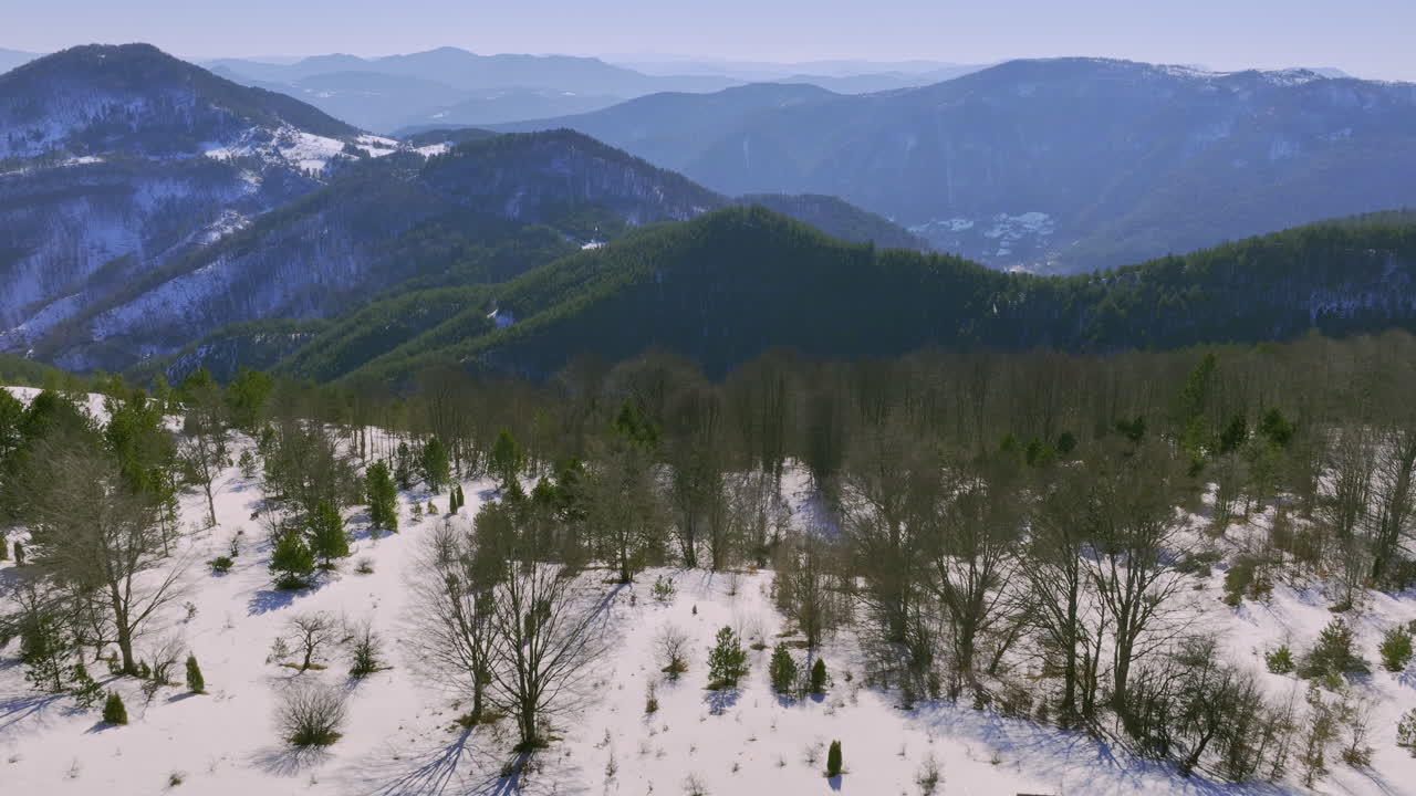 Snowy mountain landscape with a small cabin and forest