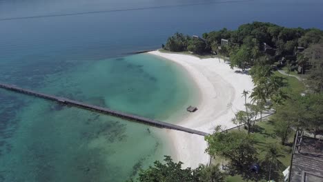 aerial view of paradise island koh kham,thailand descending slowly from the top of the resort towards the pier and white sand beach.