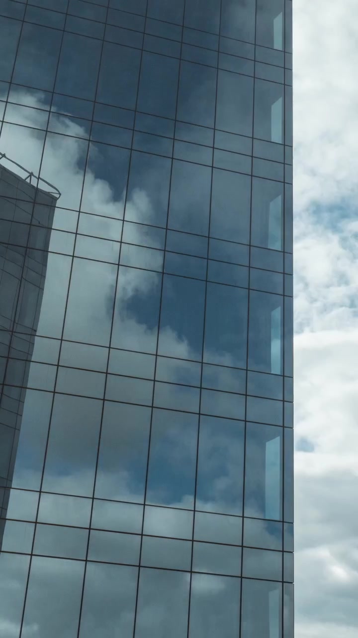 Timelapse de nuvens se movendo e refletindo em arranha-céu espelhado