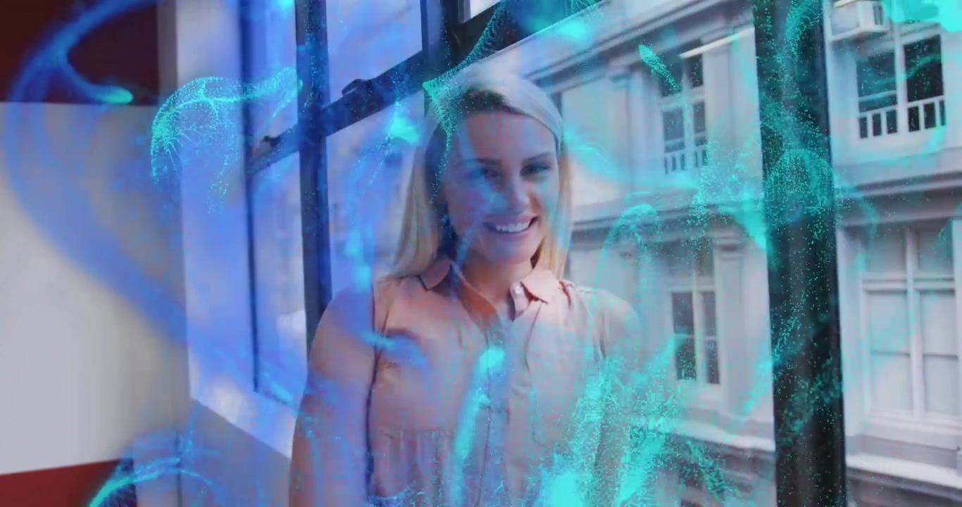 Donna ferma vicino alle finestre che permette a particelle blu di intrecciarsi in una rete di dati, visualizzando la tecnologia.