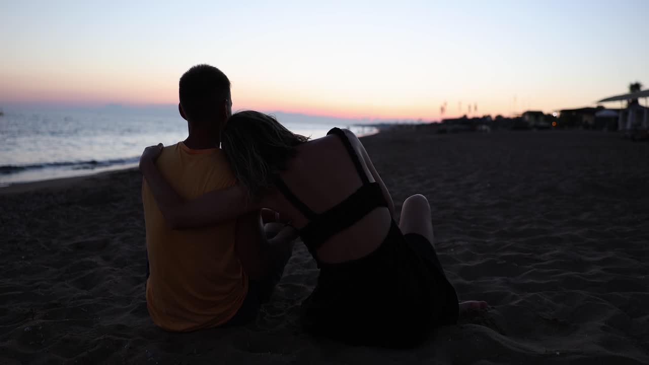 해변 에서 만적 인 일몰 을 즐기는 부부