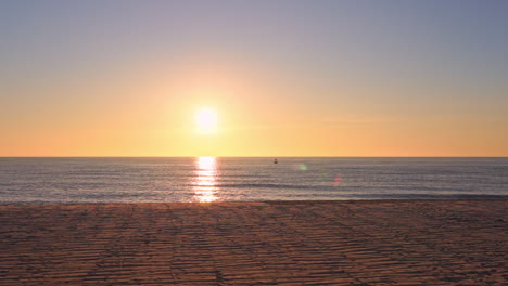 slow panning shot of golden sun going down in the sea, ocean seascape