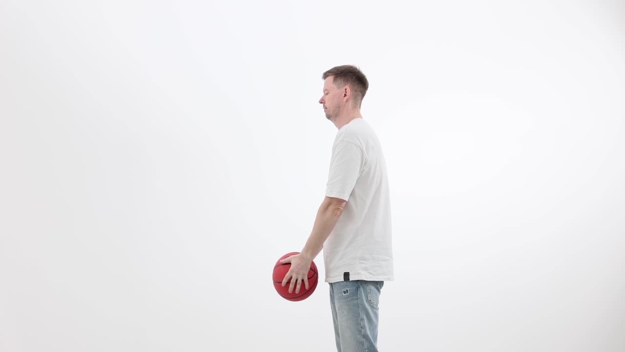 Man Tossing and Catching a Red Basketball on White Background