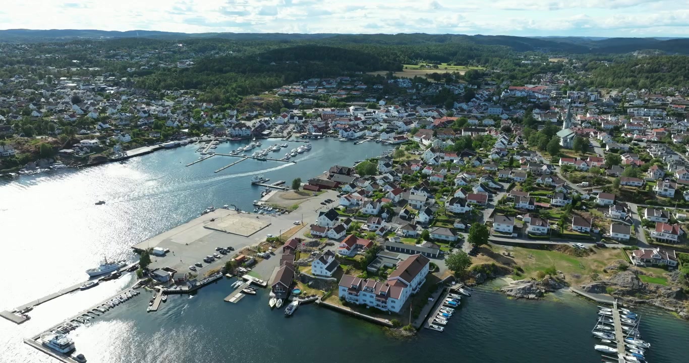 Luftfoto af kystbyen Lillesand, Norge, der viser hvide huse.