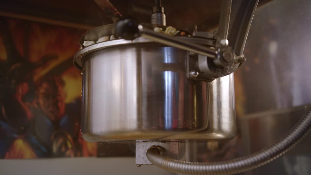 Macchina per la produzione di popcorn. I popcorn pronti cadono dalla macchina per popcorn.