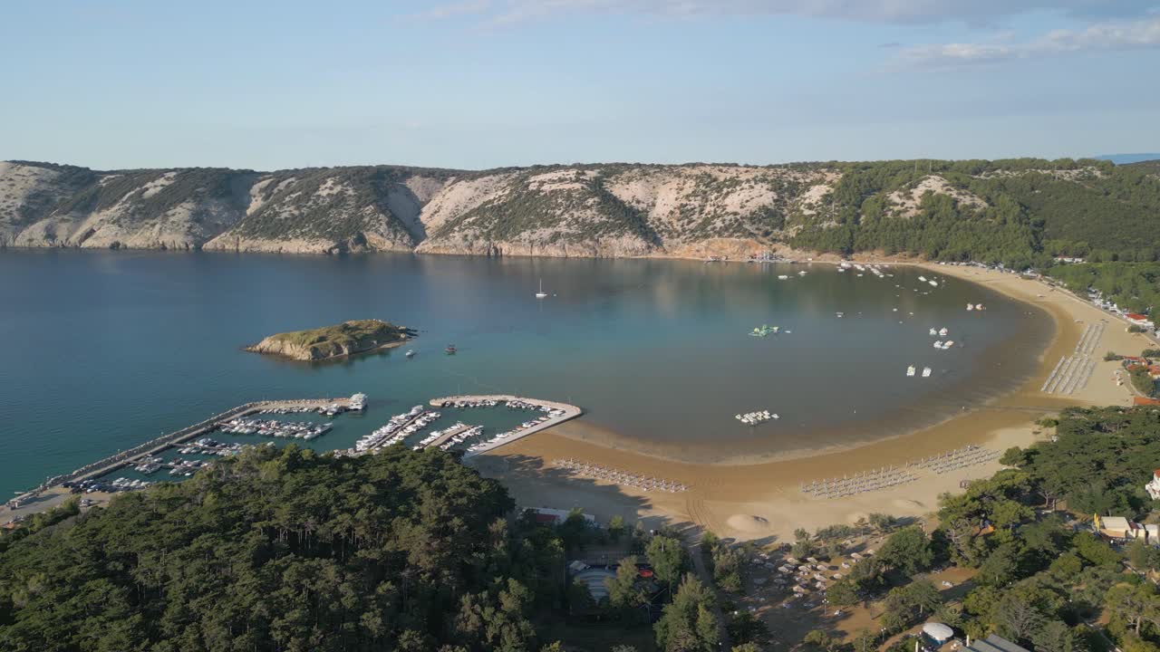 Aerial view of Lopar Croatia travel holiday destination with little port for luxury yacht and lonely remote solitary sandy beach, drone reveal seascape with hilly cliff