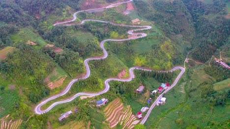 a winding wiggling road cut beautifully into the mountainside on the dong van karst plateau geopark