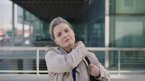 portrait of independent middle aged business woman commuter leaving work looking serious at camera in city