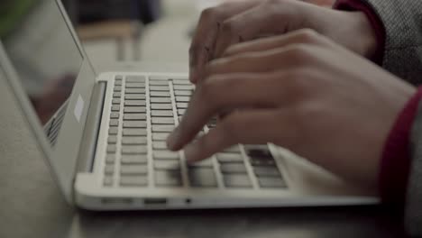 cropped shot of male hands typing on laptop computer