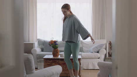 beautiful woman dancing at home practicing ballet dance moves having fun rehearsing in living room