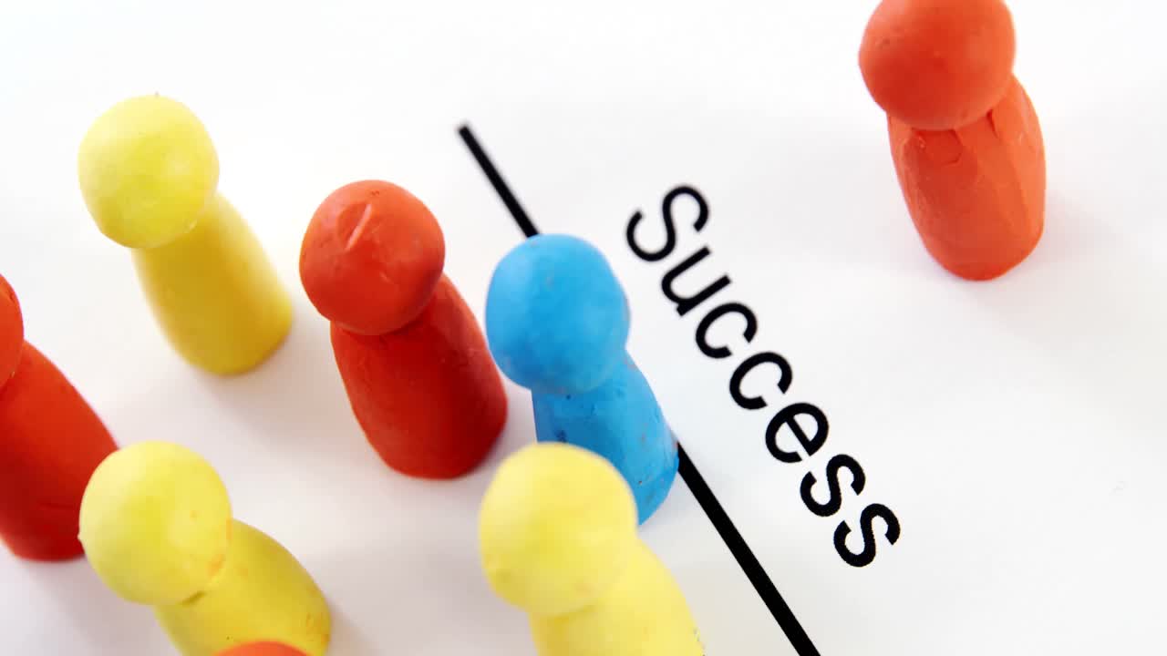 Multicolored figurines on a paper with text success