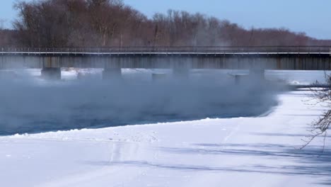 Un-Puente-Bajo-Sobre-Un-Río-Cubierto-De-Nieve