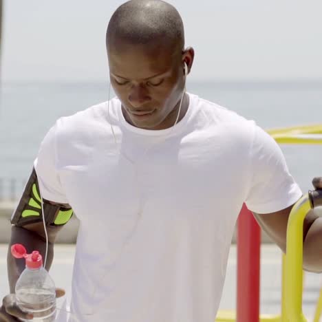 athlete with uncapped sports bottle in park