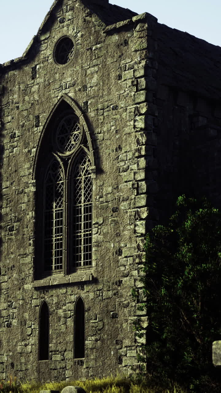 Igreja de pedra medieval com janelas ornamentadas rodeada por ruínas de fortaleza