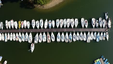 boats pier on the lake, rows of sailing boats moored by a pier