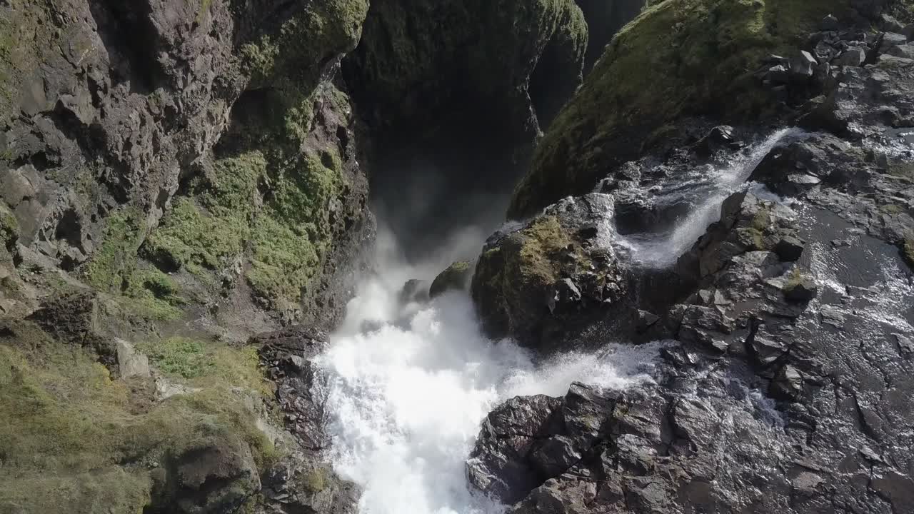 imágenes de drones de la parte superior de las cascadas de glymur en islandia mientras el agua cae por el borde