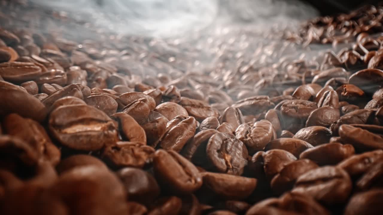 Close up of seeds of coffee. Fragrant coffee beans are roasted smoke comes from coffee beans.