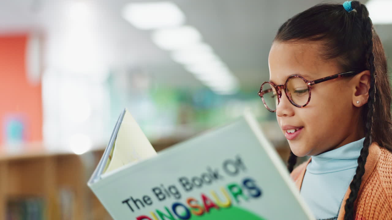 Girl reading a dinosaur book in the library