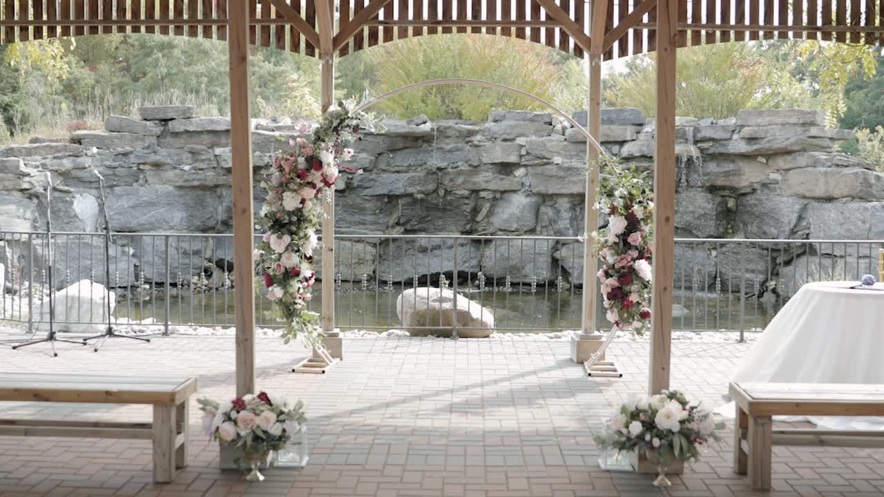 Caminando por el pasillo de un hermoso lugar para bodas al aire libre con pérgola durante el otoño en el Orchard View Wedding and Event Centre