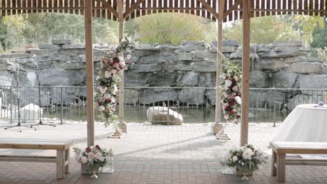 Walking-down-the-isle-of-a-beautiful-outdoor-pergola-wedding-venue-during-the-fall-at-Orchard-View-Wedding-and-Event-Centre