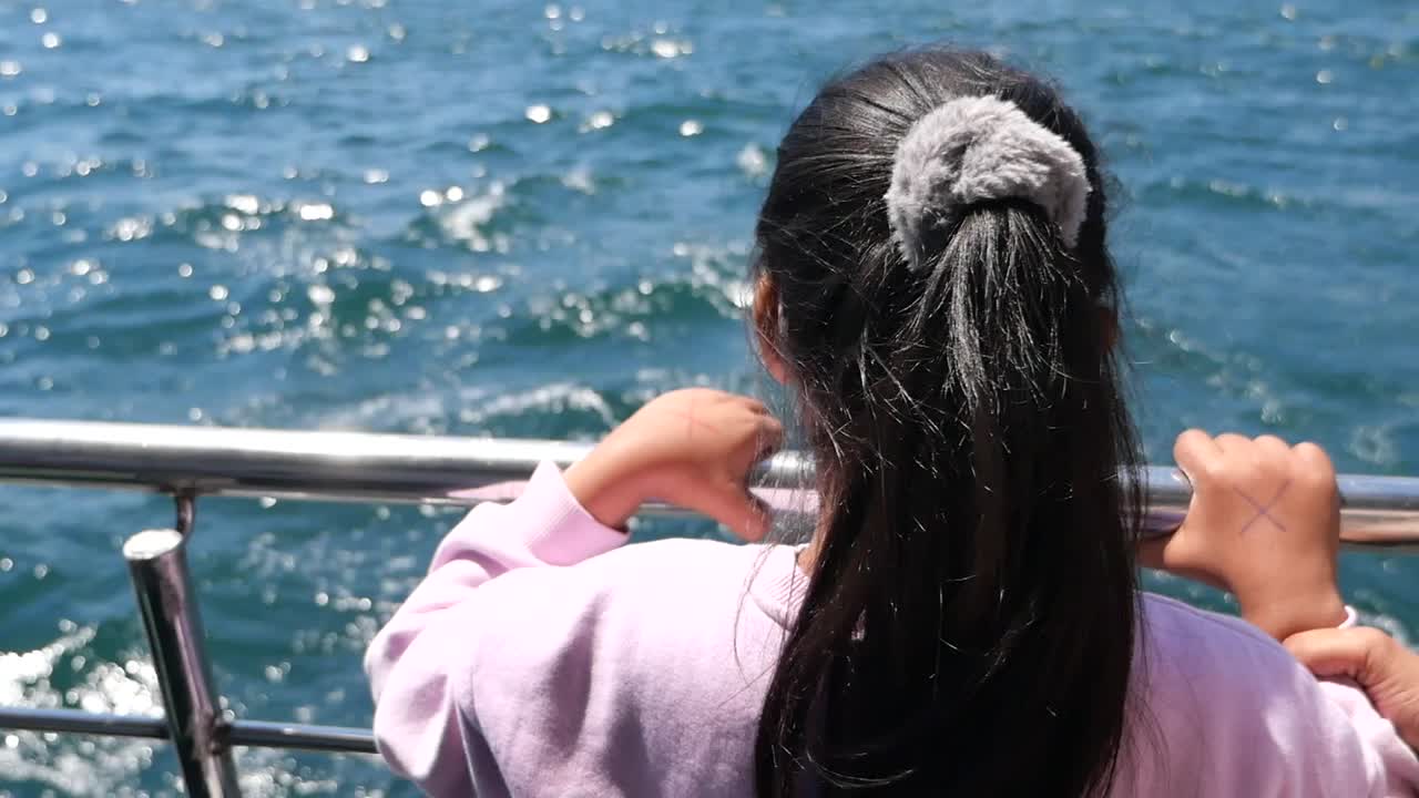 Girl looking at the ocean from a boat