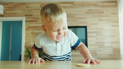 funny kid climbs on the table for the biscuit fun video with kids concept