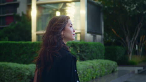 confident asian businesswoman walking alone watching city architecture side view